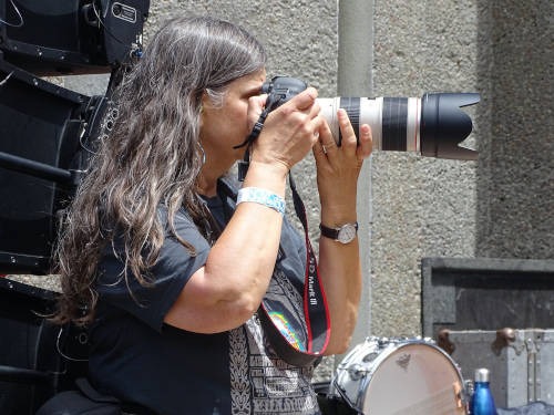 Susan photographing with a long lens backstage
